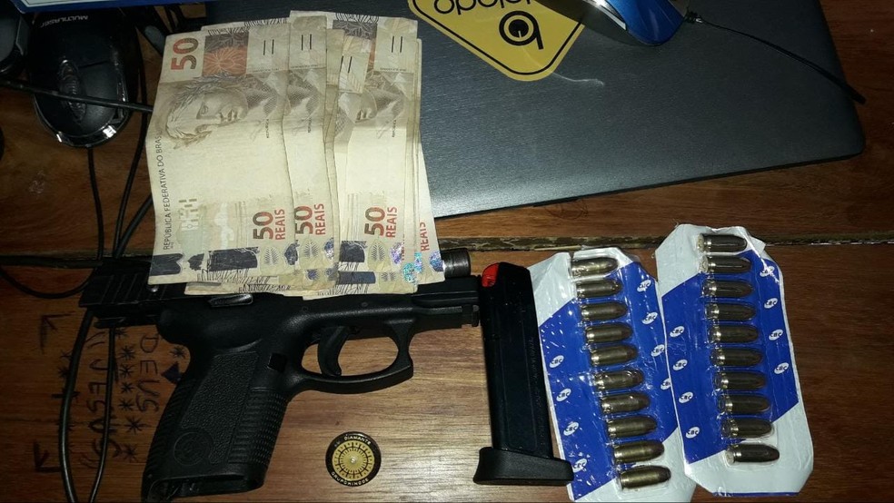 Com os criminosos, a Polícia Federal apreendeu uma arma, munições , dinheiro e um computador — Foto: Polícia Federal