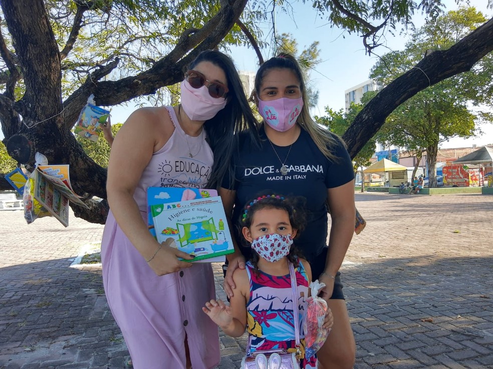 Liz, de 4 anos, doou um livro para o projeto e levou outro para casa — Foto: João Vitor Ferreira/G1