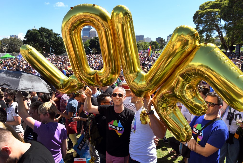 Casal comemora aprovação da população ao casamento gay na Austrália com balões que formam a palavra 