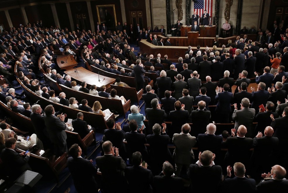 Membros da Câmara dos Representantes e do Senado dos EUA assistem à Trump em discurso de 2017; uns aplaudem o presidente de pé, enquanto outros permanecem sentados — Foto: REUTERS/Jonathan Ernst