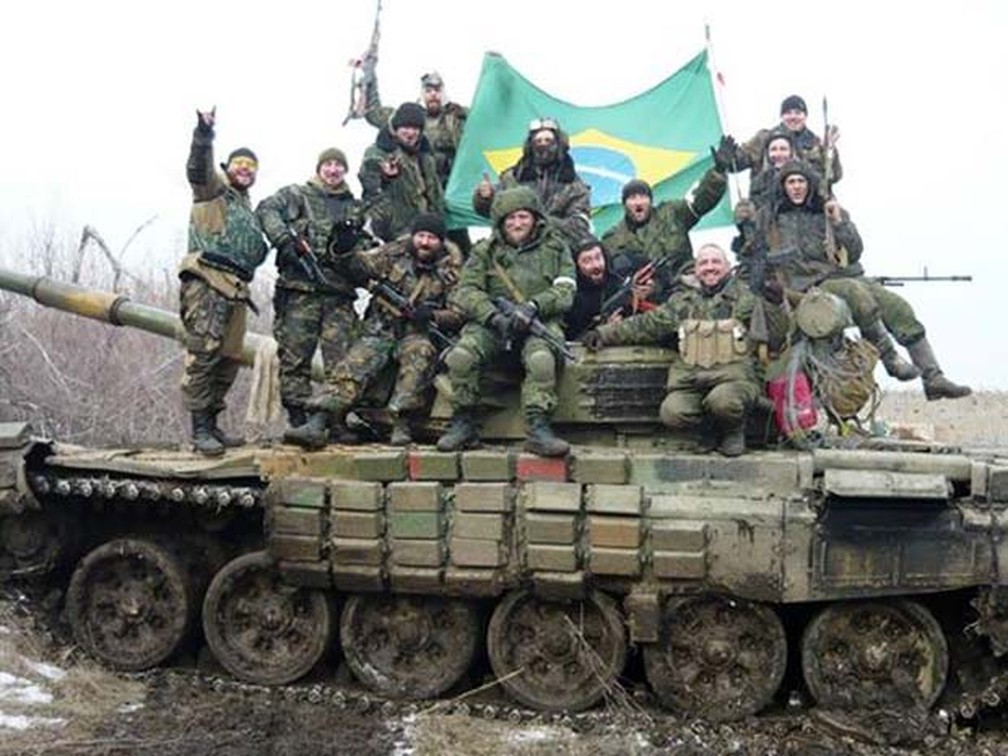 Rafael (acima à esquerda) segura bandeira brasileira ao lado de combatentes no leste da Ucrânia — Foto: Reprodução/ Facebook/ Rafael Lusvarghi
