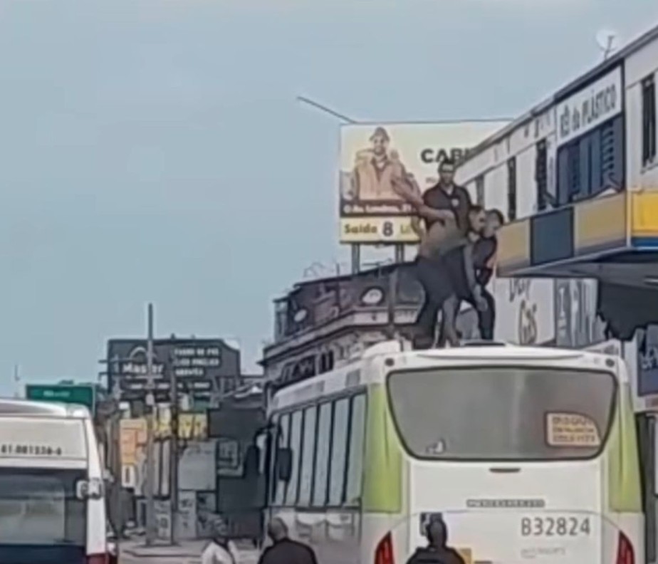 Homem é imobilizado por policiais em teto de ônibus na Avenida Brasil