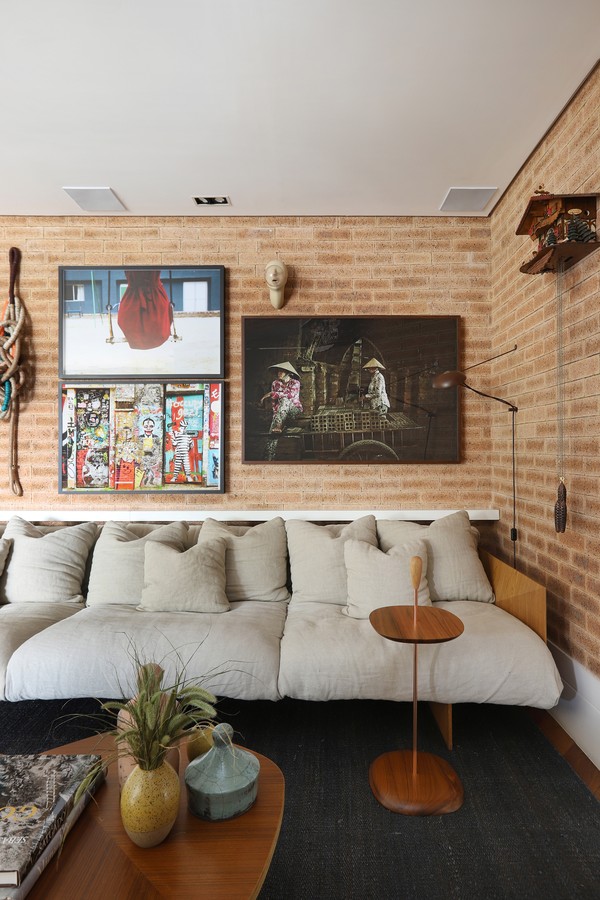 Apartamento de 148 m² tem sala revestida de tijolinhos e gallery wall  (Foto: Mariana Orsi )
