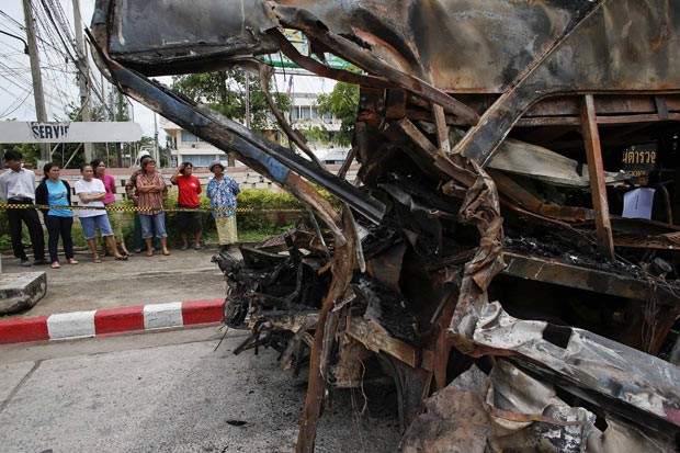 Moradores observam destroços de ônibus acidentado nesta terça-feira (23) na Tailândia (Foto: Reuters)