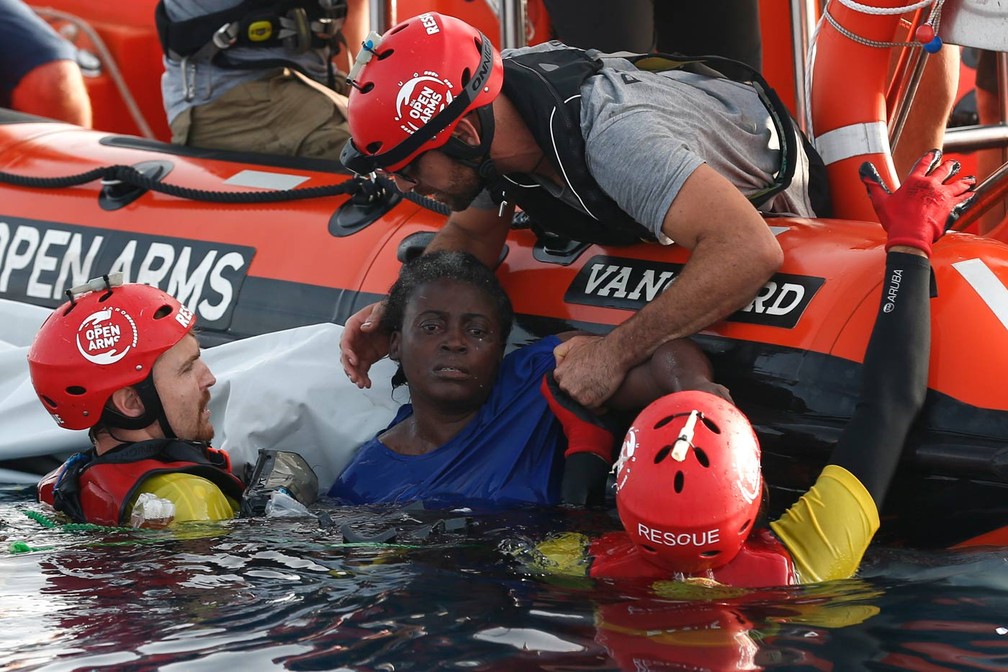 Mulher africana Ã© retirada do Mar MediterrÃ¢neo por socorristas da ONG espanhola Open Arms Fund; a organizaÃ§Ã£o acusou o governo lÃ­bio de afundar o barco para obrigar os imigrantes a aceitarem o retorno forÃ§ado Ã  LÃ­bia (Foto: Pau Barrena/AFP)