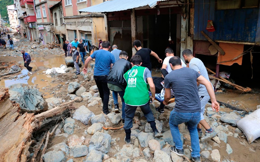  Pessoa ferida é retirada de escombros após inundação na cidade de Dereli, na província de Giresun, na Turquia, no domingo (23) — Foto: AP Photo