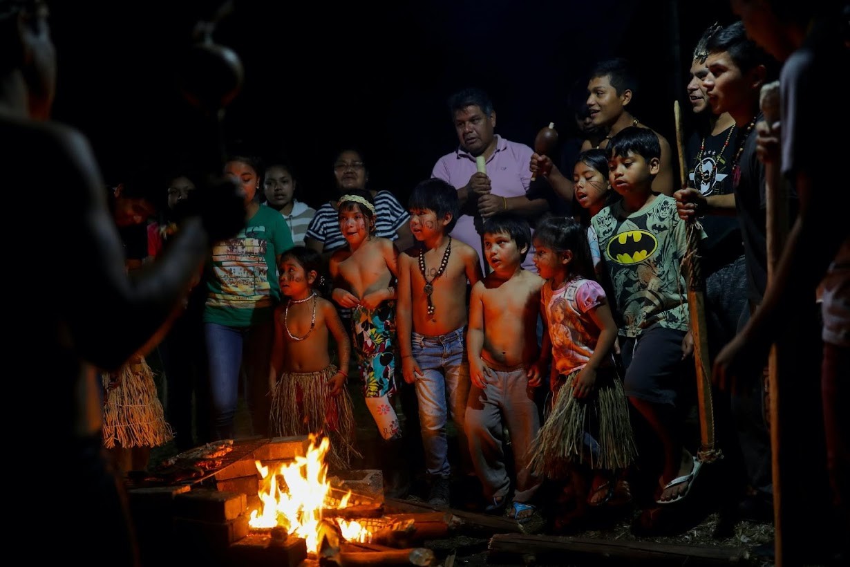 Indígenas xokleng cantam ao redor da fogueira (Foto: Reuters)