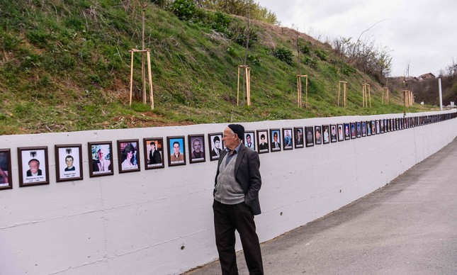 Homem observa memorial de vítimas de um dos massacres contra albaneses no Kosovo, em 2019