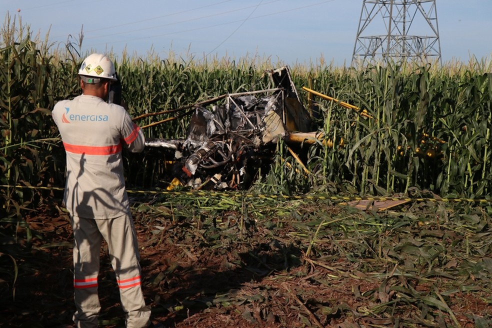 Funcionário da Energisa observa avião que caiu após bater em fio de alta-tensão em Nova Mutum — Foto: Djeferson Kronbauer/Power Mix