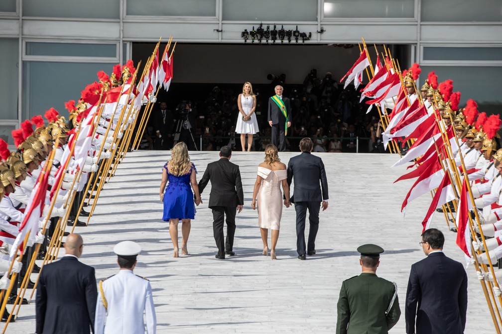 Bolsonaro sobe a rampa do Palácio do Planalto acompanhado de sua mulher, Michelle, além do vice-presidente Mourão e sua mulher, enquanto Michel Temer o aguarda no topo — Foto: Fábio Tito/G1