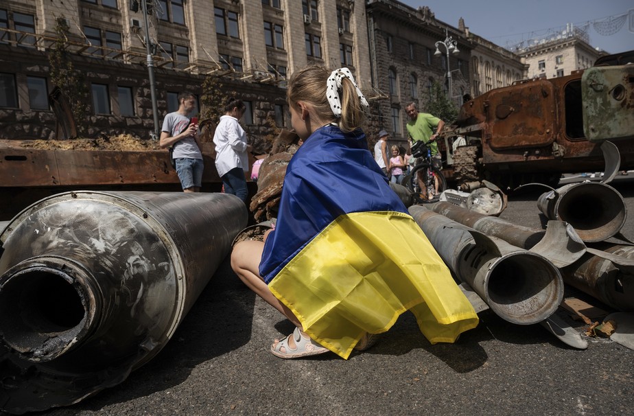 Famílias ucranianas observam veículos e equipamentos militares exibidos no centro de Kiev