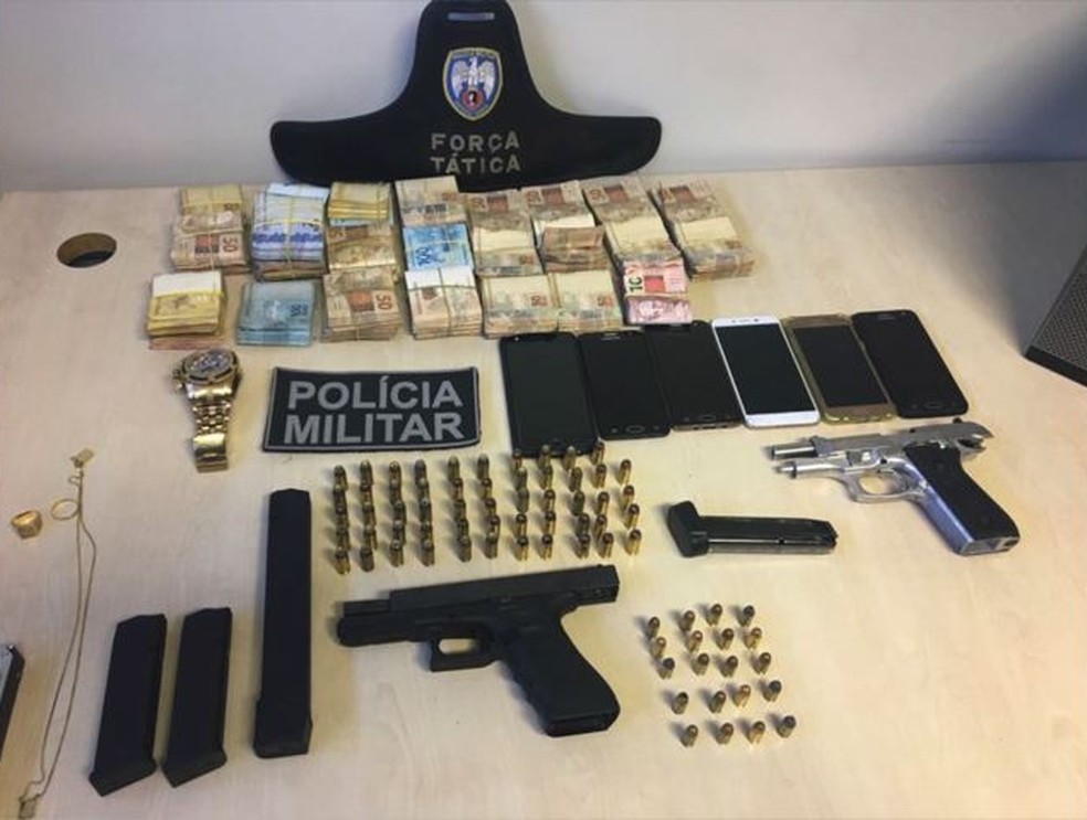 Dinheiro roubado na agência dos Correios de Coqueiral de Aracruz e armas usadas no crime (Foto: Divulgação/Polícia Militar)
