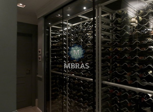 BAR + ADEGA | OeEspaço onde é armazenado os vinhos fica ao lado oposto dos sofás (Foto: Divulgação / MBRAS)