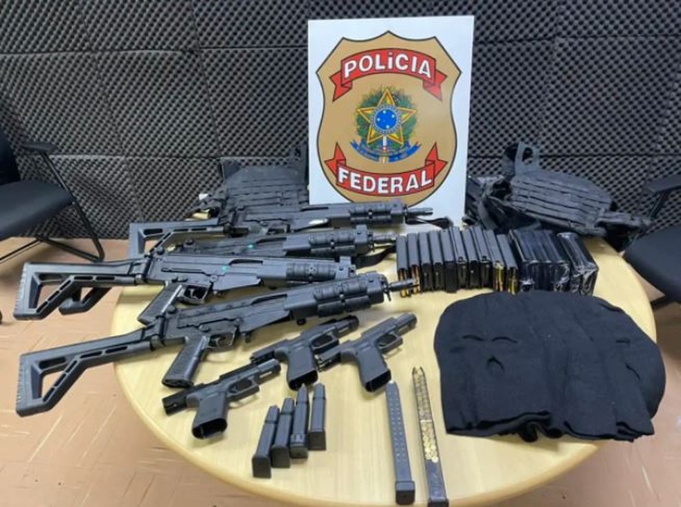 Fuzis, pistolas 9mm, toucas e outros objetos apreendidos pela PF. — Foto: Polícia Federal