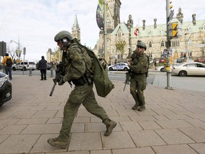 Militares armados caminham em direção ao bloco Langevin, na Colina do Parlamento, em Ottawa (Foto: Chris Wattie/Reuters)