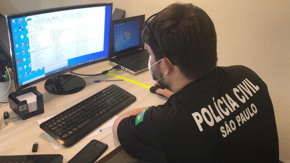 Policial investiga computador apreendido durante operação Black Dolphin — Foto: Arquivo Pessoal