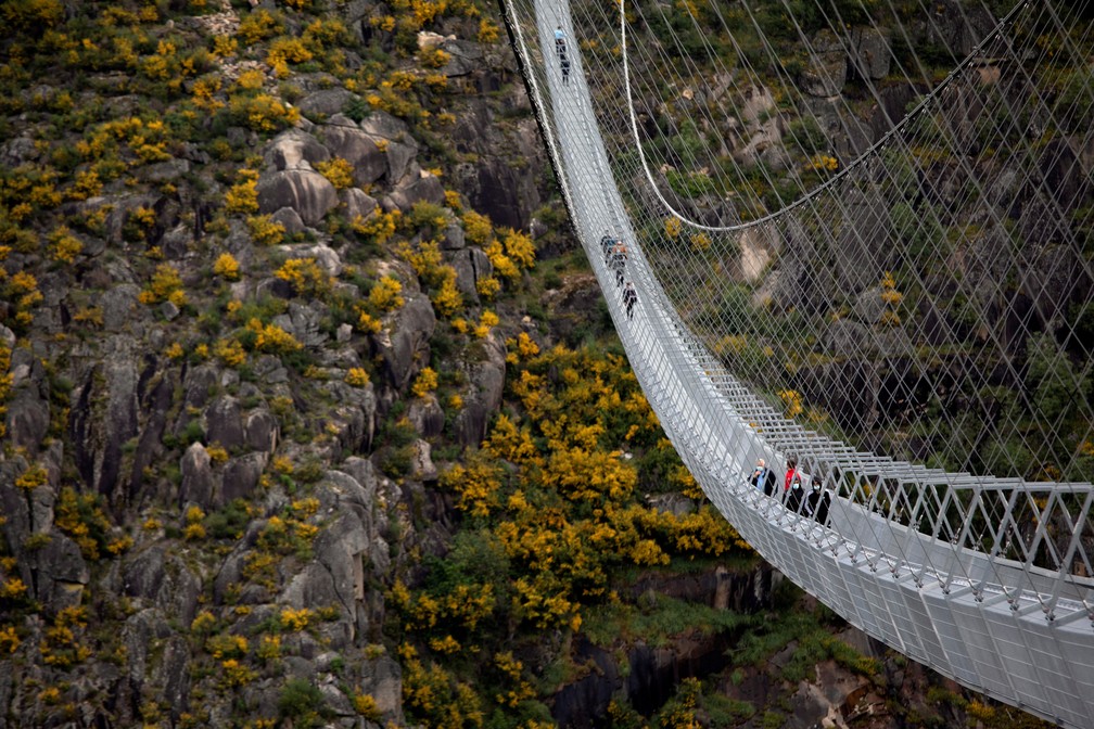 Pessoas atravessam a maior ponte suspensa para pedestres do mundo, a '516 Arouca', agora aberta para residentes locais no norte de Portugal, em 29 de abril de 2021 — Foto: Violeta Santos Moura/Reuters