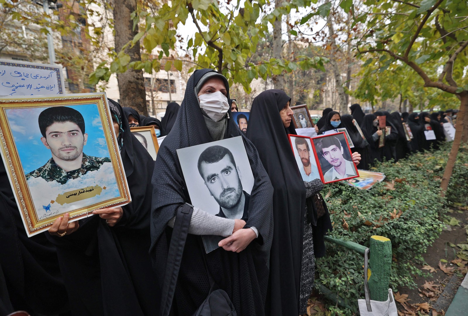 Mulheres se reúnem com retratos de soldados mortos na guerra Irã-Iraque dos anos 1980, em frente à sede das Nações Unidas na capital do Irã, Teerã — Foto: ATTA KENARE / AFP