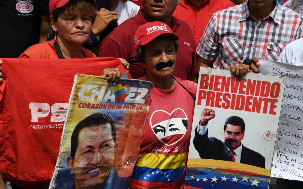 Apoiadores celebram o ex-presidente Hugo Chávez nas comemorações do Dia do Trabalhador — Foto: Yuri Cortez/AFP