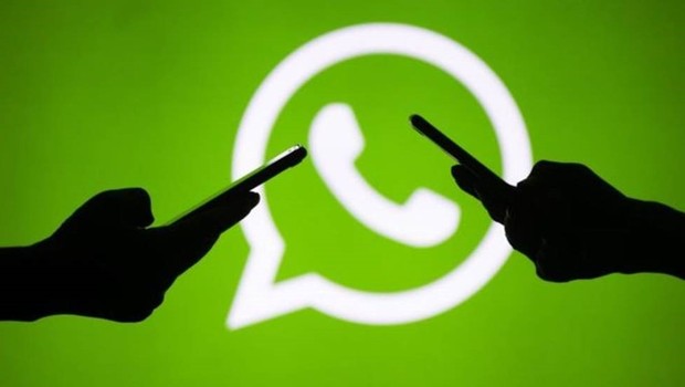 Logo do WhatsApp com duas mãos usando smartphones (Foto: Getty Images via BBC)