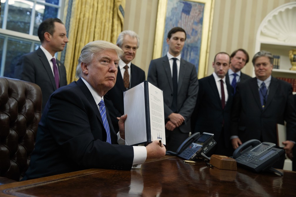Imagem de 23 de janeiro de 2017 mostra Trump no Salão Oval da Casa Branca após assinar ordem executiva que proíbe governo dos EUA de financiar grupos pró-aborto no exterior — Foto: AP Photo/Evan Vucci
