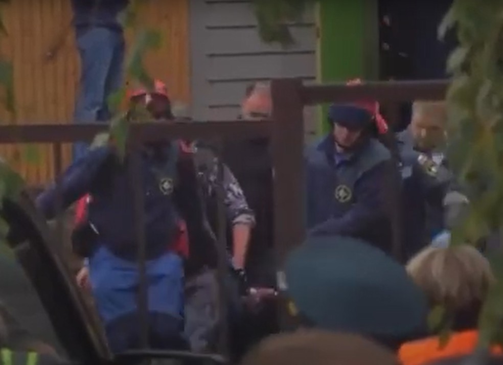 Policiais retiram corpo de dentro de escola onde um homem disparou tiros e depois se suicidou, na Rússia — Foto: Reprodução de vídeo