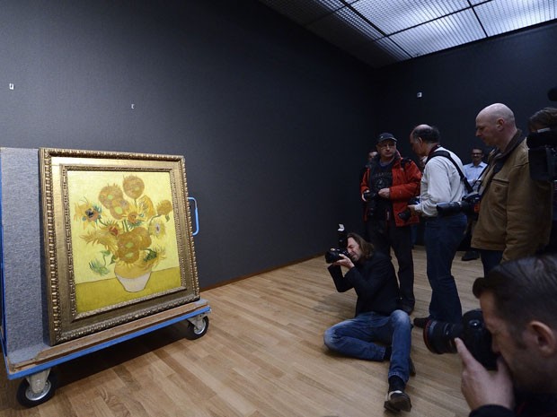 Fotógrafos registram o quadro 'Girassóis' na reabertura do museu Van Gogh, em Amsterdã, nesta quarta-feira (1º/5/2013); a obra de 1988 é uma das principais do artista holandês (Foto: Koen Van Wee/AFP)