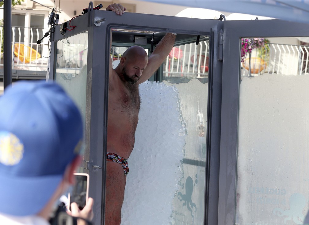 O nadador austríaco Josef Koeberl deixa cabine de vidro cheia de gelo, depois de estabelecer novo recorde dentro de caixa com gelo, em Melk, Áustria — Foto: Ronald Zak/AP