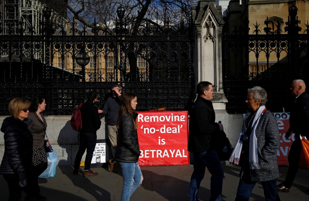 Pessoas em frente a manifestação favorável ao Brexit perto do Parlamento britânico — Foto: Henry Nicholls/Reuters
