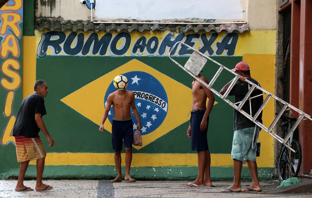 11 de junho â Pessoas jogam futebol em frente a um mural pintado para a Copa do Mundo 2018, no bairro da GlÃ³ria, no Rio de Janeiro â Foto: Sergio Moraes/Reuters