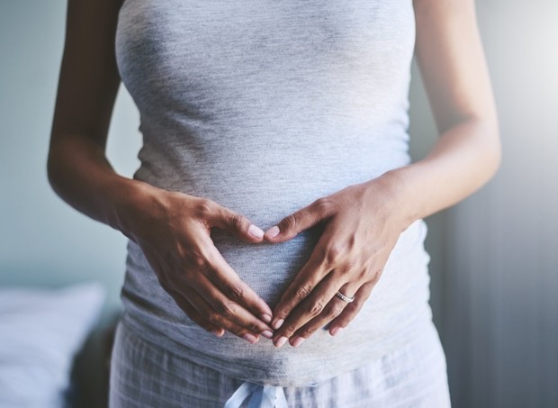 Grávida com a mão na barriga (Foto: Getty Images)