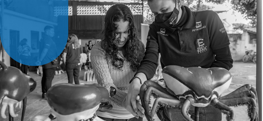 Jovem aprende sobre o caranguejo, símbolo dos mangues, com as mãos: iniciativa de educação pioneira