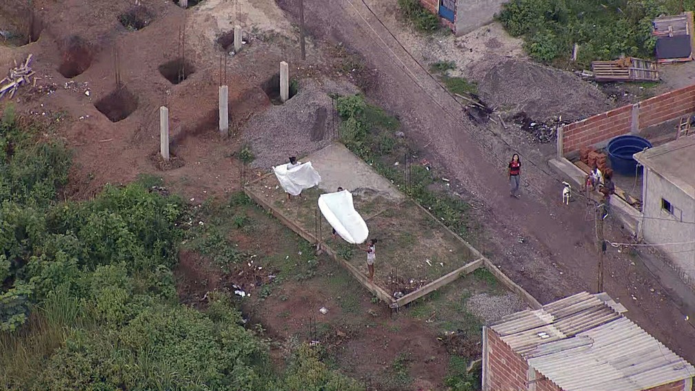Moradores da Vila Cruzeiro estendem lençóis brancos pedindo paz — Foto: Reprodução/TV Globo