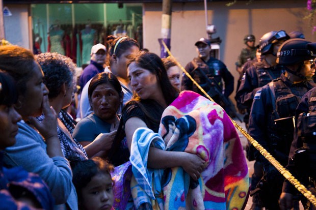 Mulheres com seus filhos aguardam informações do lado de fora do abrigo mexicano onde operação resgatou mais 450 crianças no México (Foto: Hector Guerrero/AFP)
