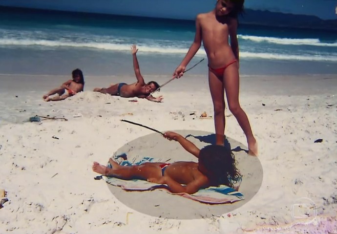 Carol Castro, quando criança, brinca na areia (Foto: TV Globo)