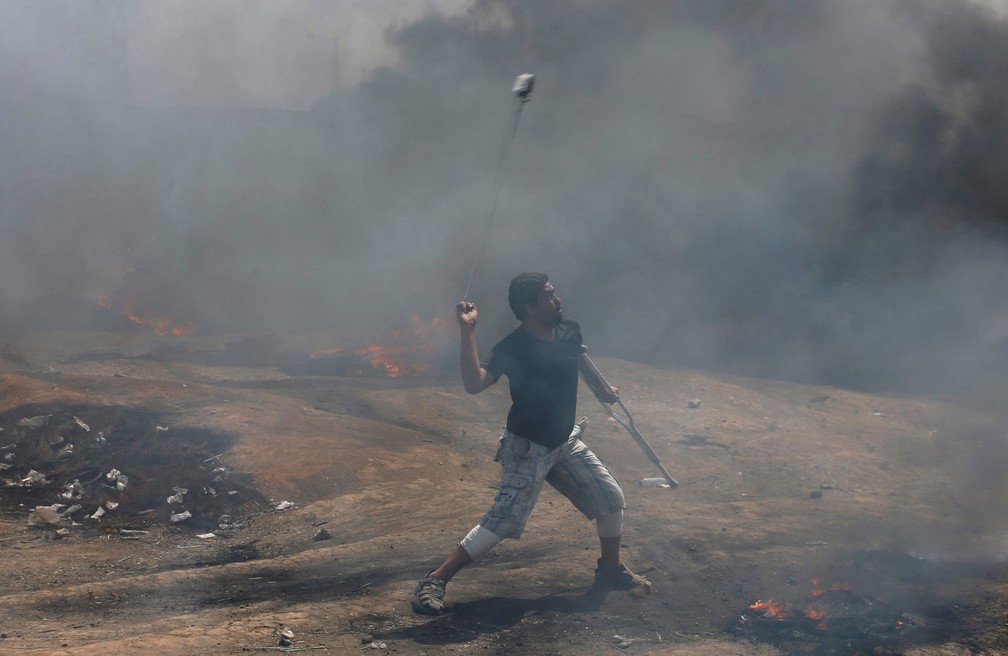 Palestino lança pedras contra soldados israelenses durante na fronteira da protesto na Faixa de Gaza com Israel (Foto: Mohammed Salem/Reuters)