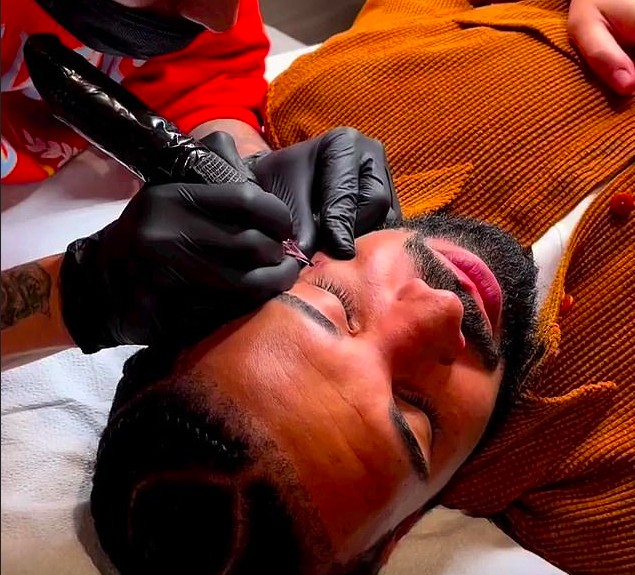 O rapper Drake fazendo a tatuagem com a homenagem à mãe no rosto (Foto: Instagram)