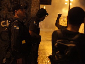 PMs tentam se proteger ao observar ação de manifestantes no Centro do Rio (Foto: Rodrigo Gorosito/G1)