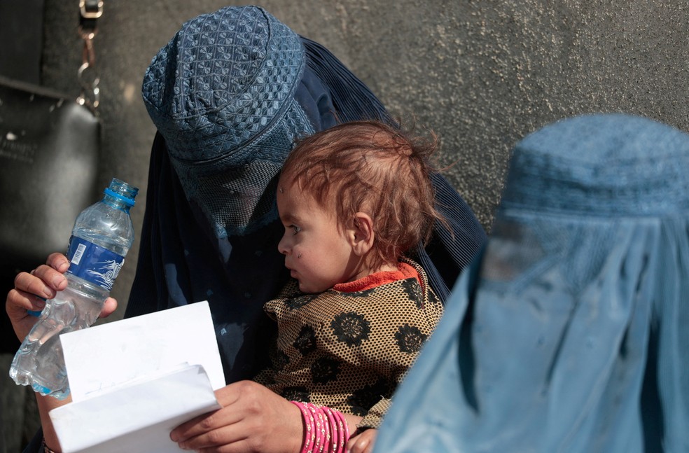 Uma mulher com filho espera em fila da agência de refugiados da ONU em Cabul. Talebã retomou o controle do país em 2021.  — Foto: Reuters