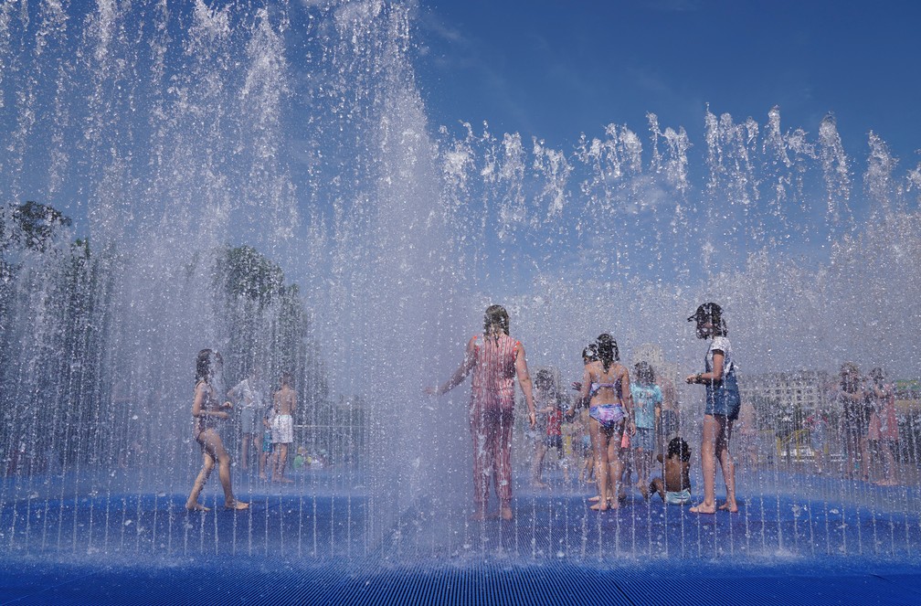 Em Londres, crianças se refrescam em fonte de água neste domingo (17) em meio à onda de calor que assola o Reino Unido. — Foto: Maja Smiejkowska/Reuters