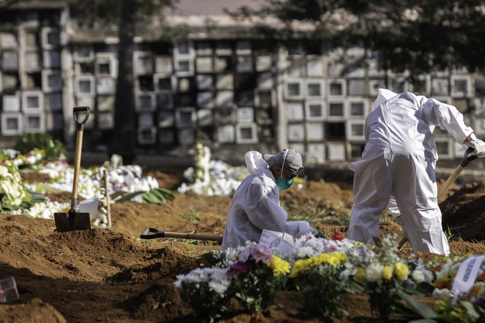 Funcion&aacute;rios trabalham no sepultamento de v&iacute;timas da Covid-19 no Cemit&eacute;rio Vila Formosa, Zona Leste de S&atilde;o Paulo, na manh&atilde; de ter&ccedil;a-feira (30) &mdash; Foto: Bruno Rocha/Fotoarena/Estad&atilde;o Conte&uacute;do