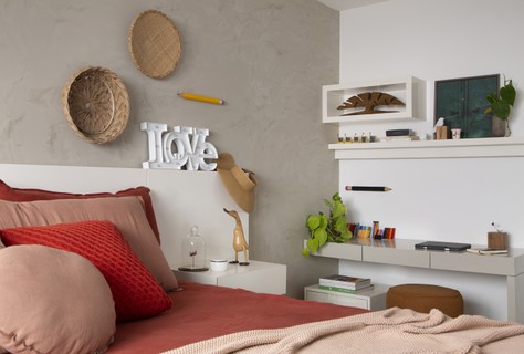 A arquiteta Amanda Miranda desenhou cabeceiras com mesas acopladas, bancada, prateleiras e nicho de parede para este quarto