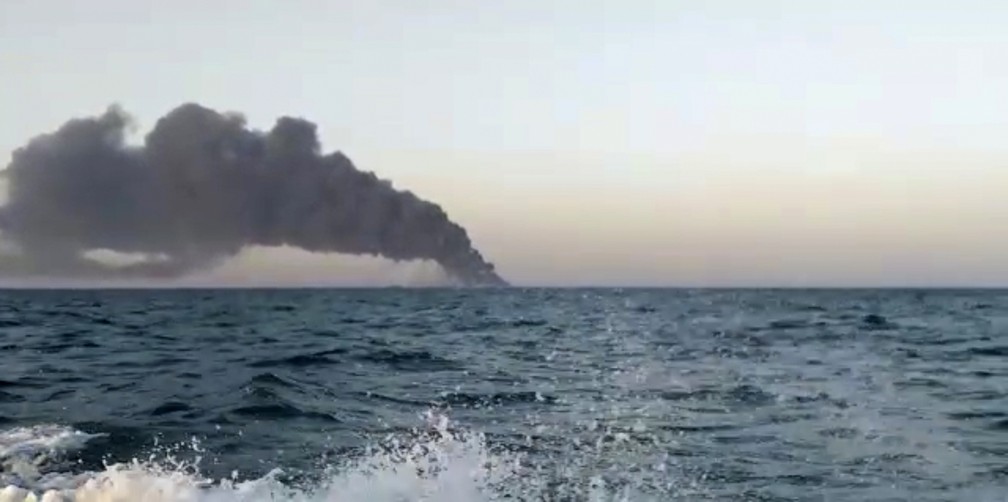 Imagem feita a partir de um vídeo divulgado em 2 de junho de 2021 pelo site Asriran.com mostra fumaça subindo do Kharg, maior navio de guerra da Marinha do Irã, que pegou fogo e afundou no Golfo de Omã — Foto: Asriran.com via AP