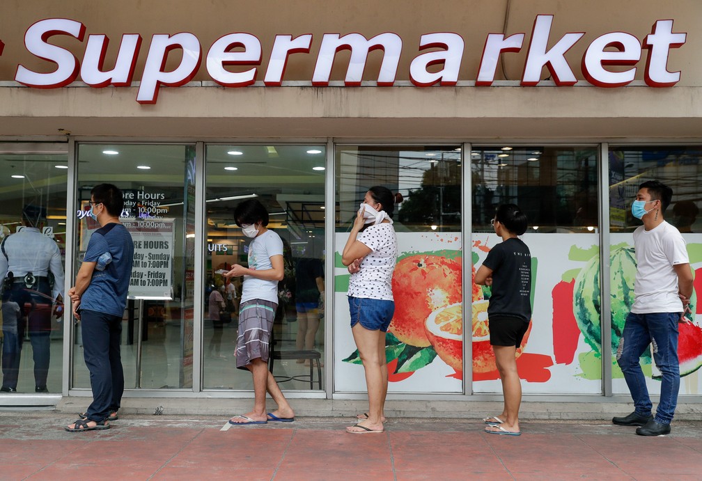 17 de março - Pessoas mantém distância uma das outras em fila para fazerem compras em um supermercado durante epidemia do novo coronavírus em Manila, nas Filipinas — Foto: Aaron Favila/AP