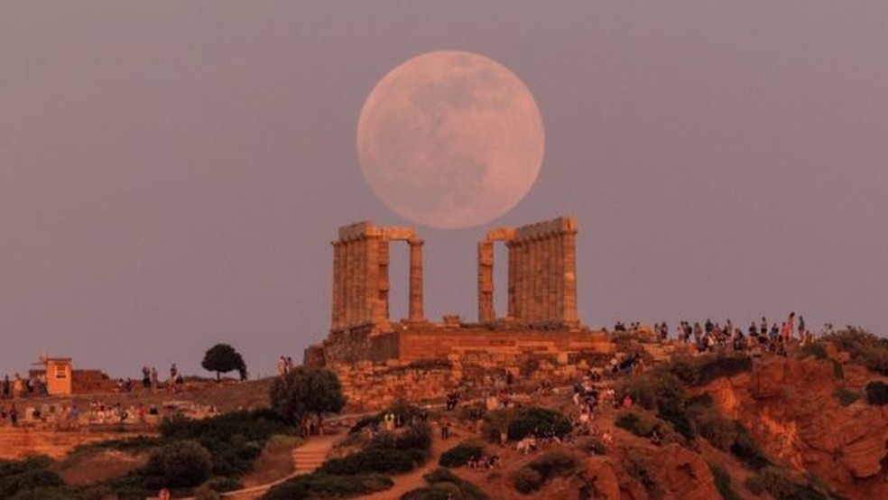 Na Grécia, pessoas se reuniram no Templo de Poseidon, perto de Atenas, para observar a Lua antes do eclipse total — Foto: REUTERS/BBC