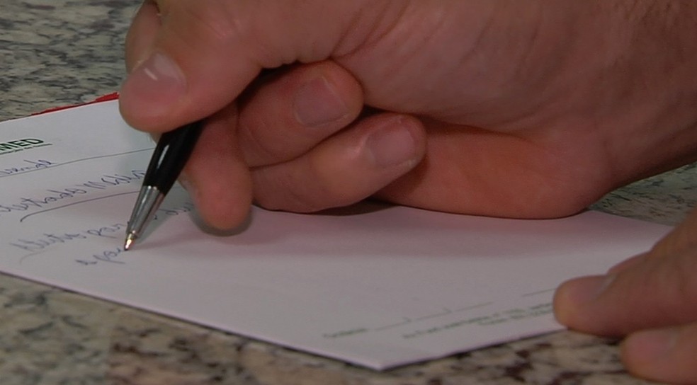 Profissional assina atestado médico — Foto: TV Anhanguera/Reprodução