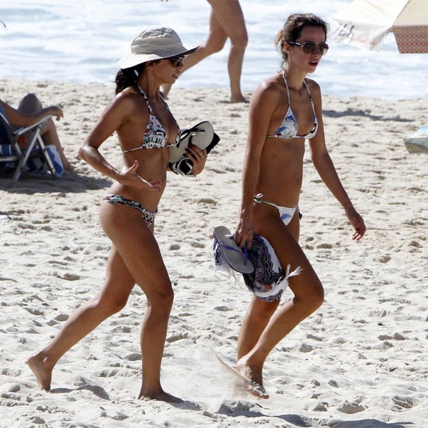 Ana curte praia na companhia de amiga e se protege do sol com chapéu (Foto: AgNews)