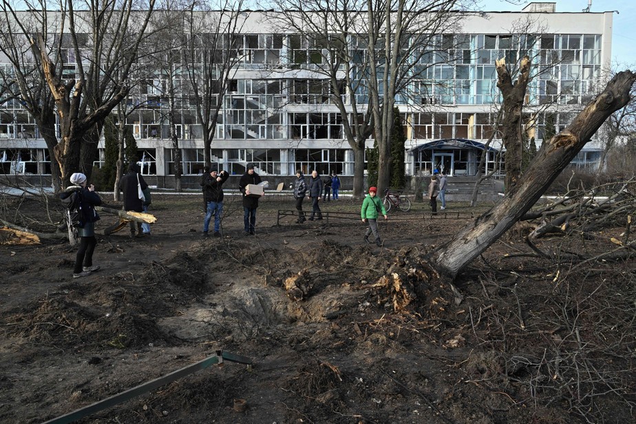 Ucranianos observam prédio destruído em Kiev no dia 1º de janeiro