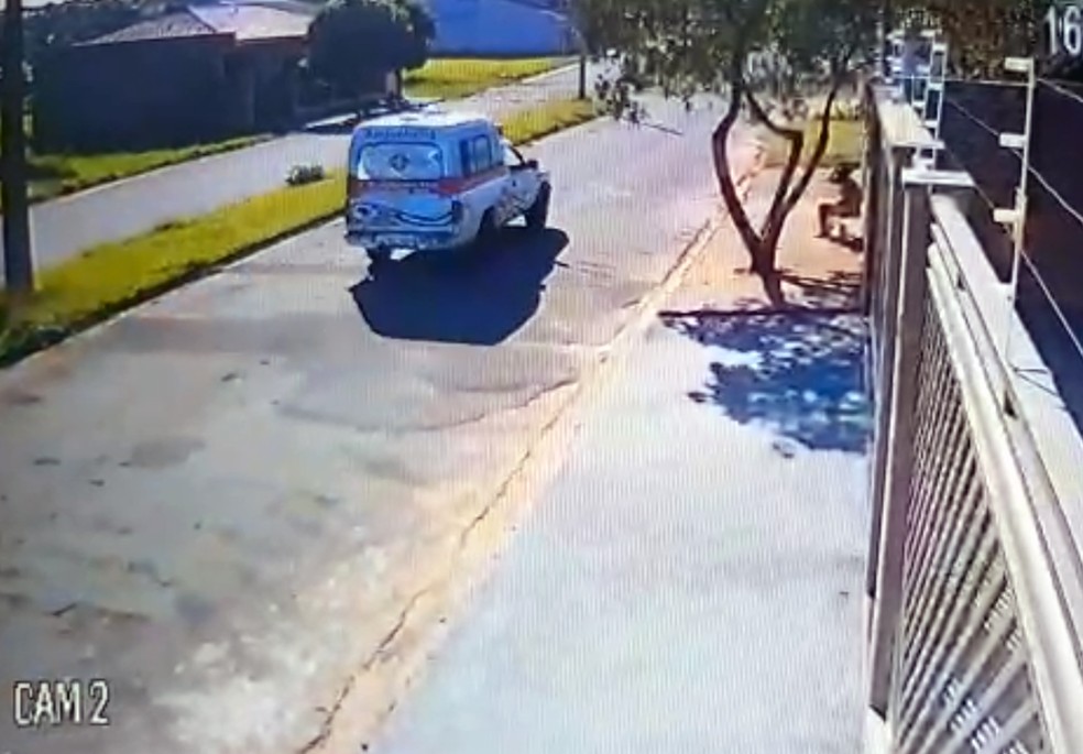 Imagens de segurança mostram a mulher sentada em frente à casa do idoso e uma ambulância passando na rua (Foto: Polícia Civil/Cedida)