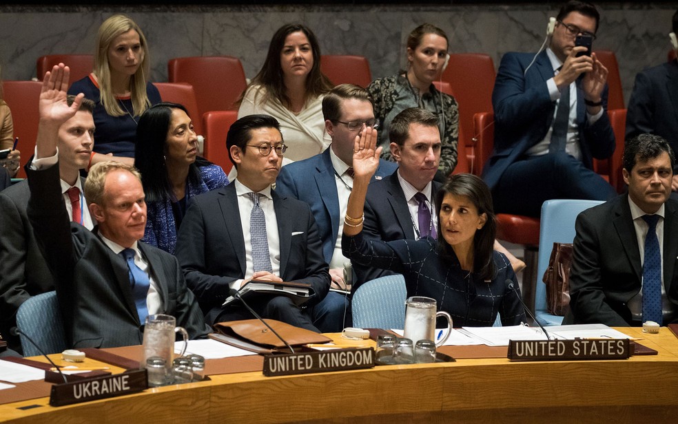 Embaixador do Reino Unido na ONU, Matthew Rycroft, e a embaixadora dos EUA, Nikki Haley, levantam as mãos durante votação de novas sanções contra a Coreia do Norte na sede do Conselho de Segurança da Onu, em Nova York, na segunda-feira (11) (Foto: Drew Angerer/Getty Images/AFP)